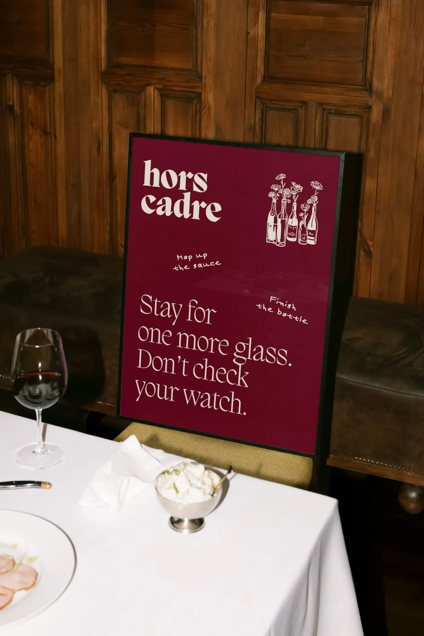 Framed Hors Cadre poster on a banquette: Stay for one more glass