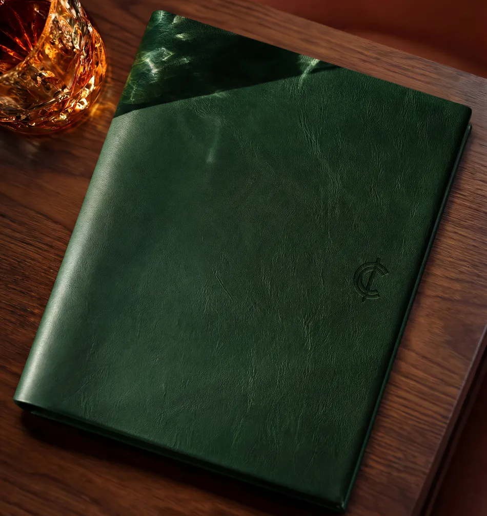Green leather menu cover with a debossed Cooper's Cut monogram